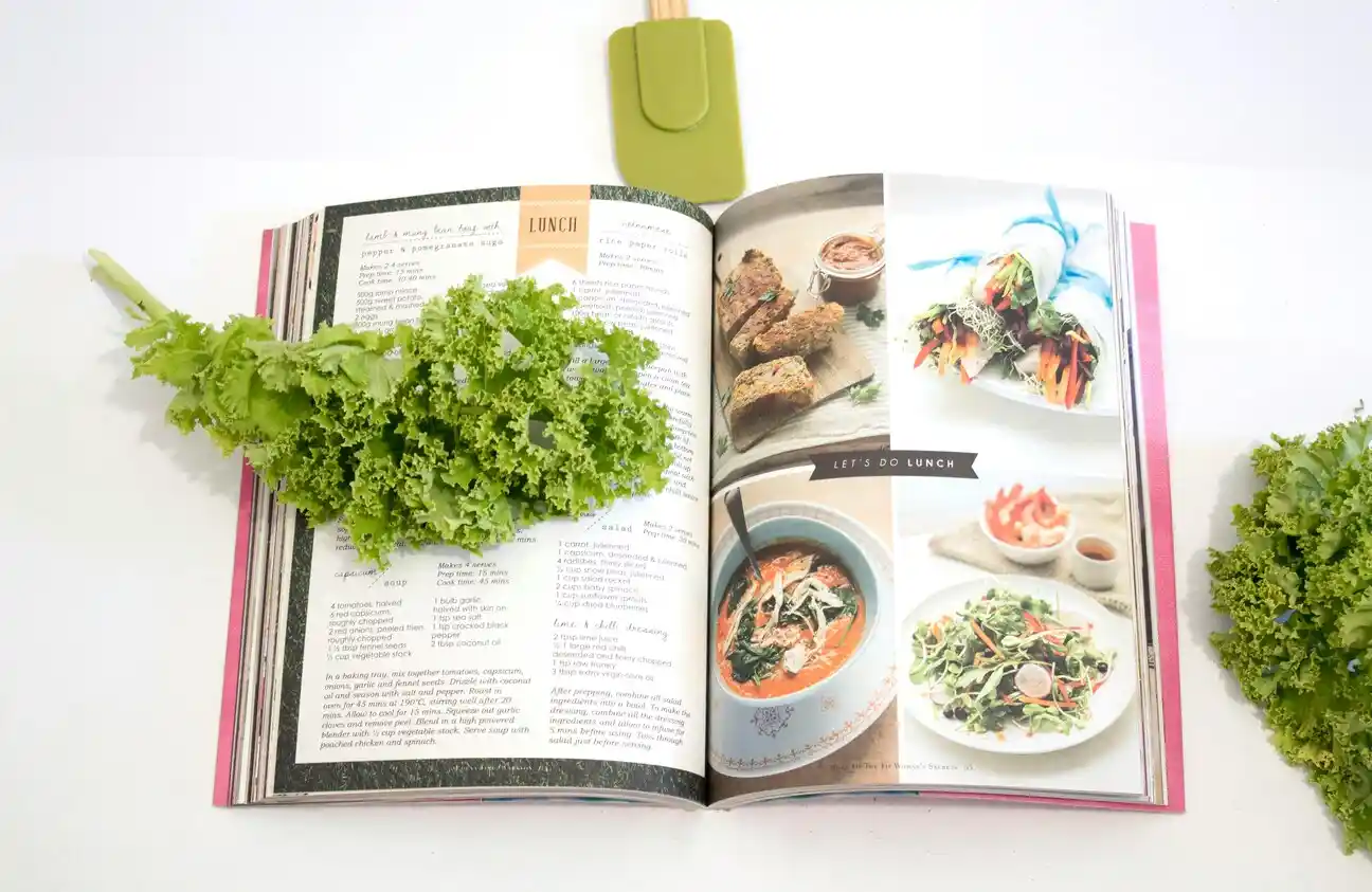 Recipe book with open pages and lettuce.